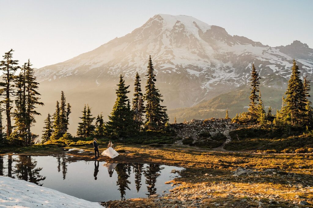 Bride and groom dance by an alpine lake at their Mt Rainier adventure elopement