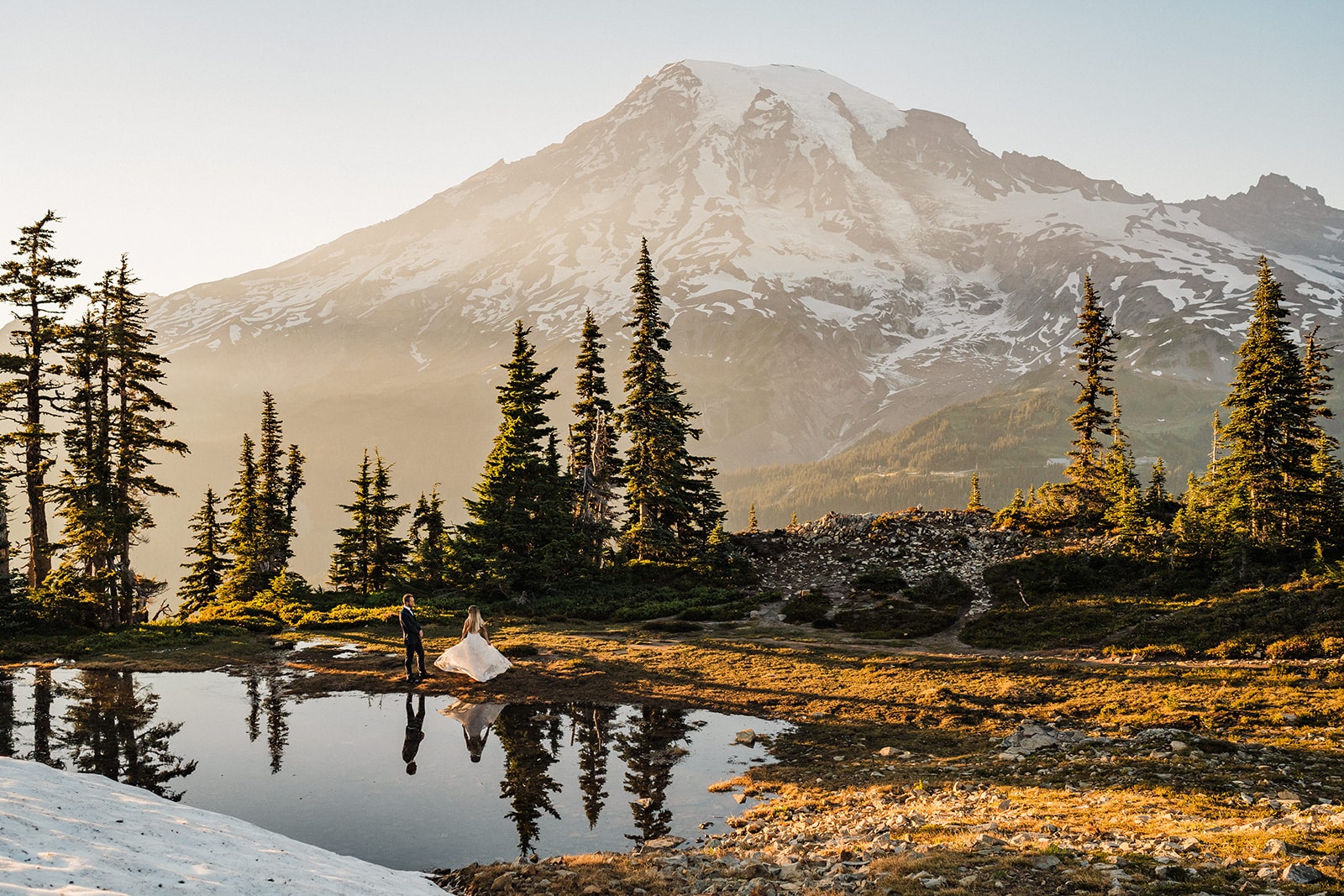 Bride and groom dance by an alpine lake during their wedding at a national park in Washington