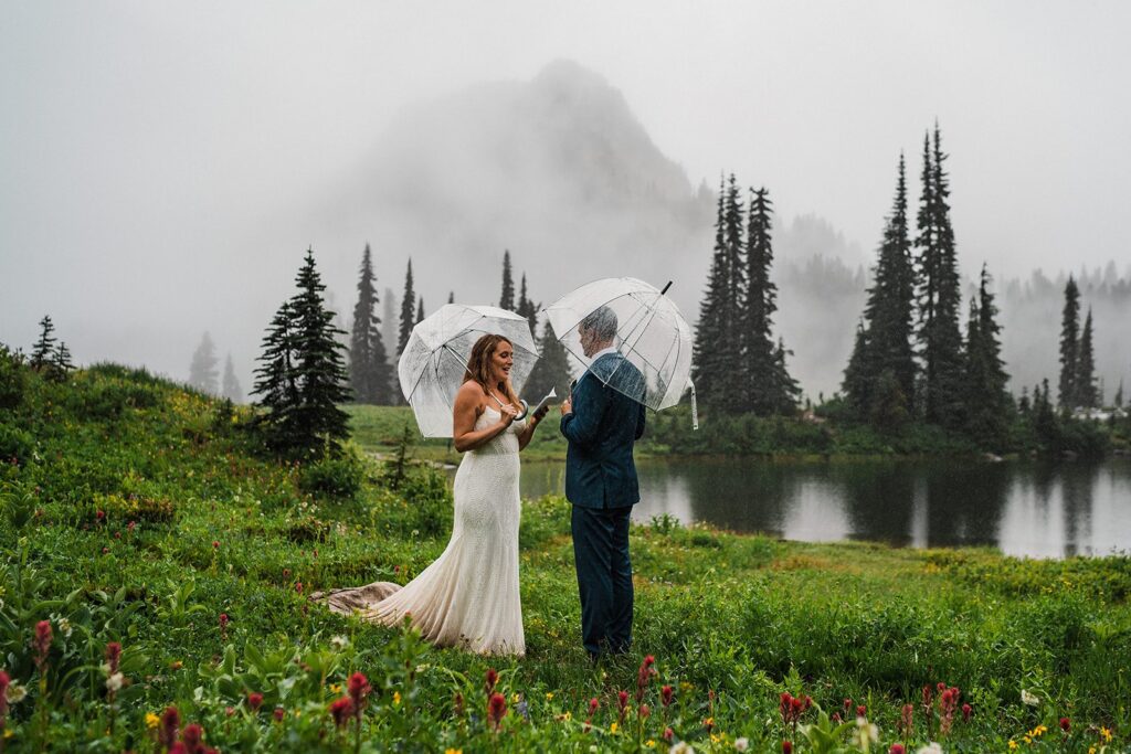 Bride and groom hold umbrellas during their rainy adventure elopement in Washington