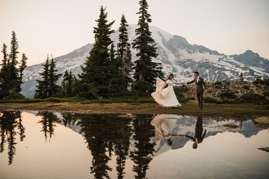 Bride and groom dance by an alpine lake at their Mt Rainier adventure elopement