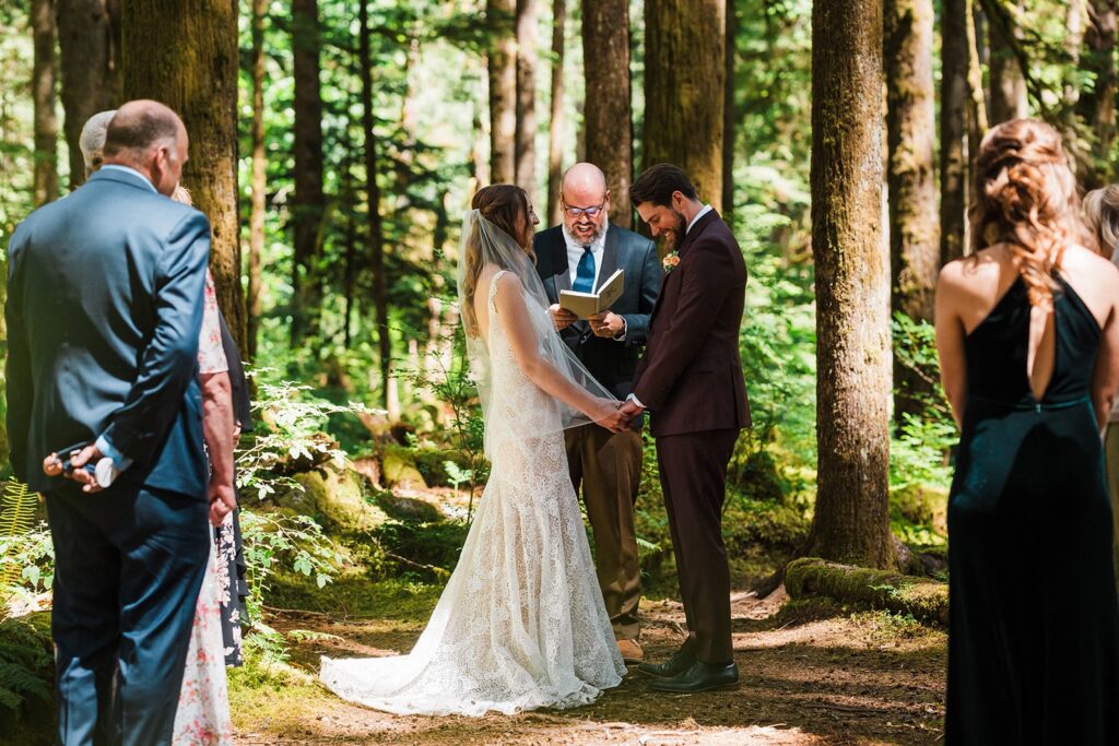 Bride and groom hold hands during their intimate cabin wedding ceremony in Snoqualmie Valley