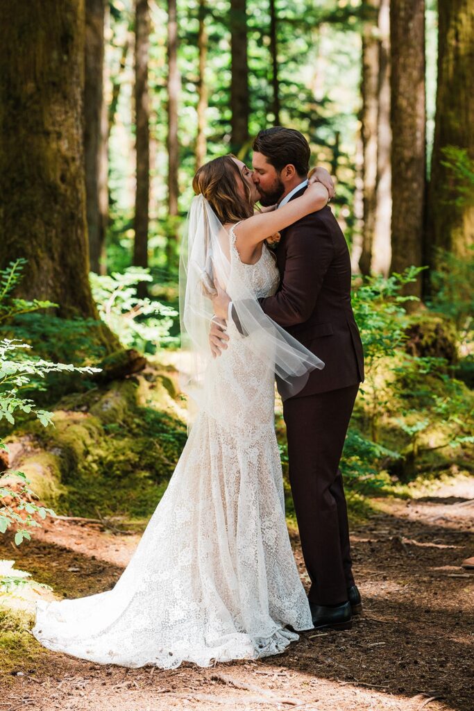 Bride and groom kiss during their forest wedding ceremony in Snoqualmie Valley