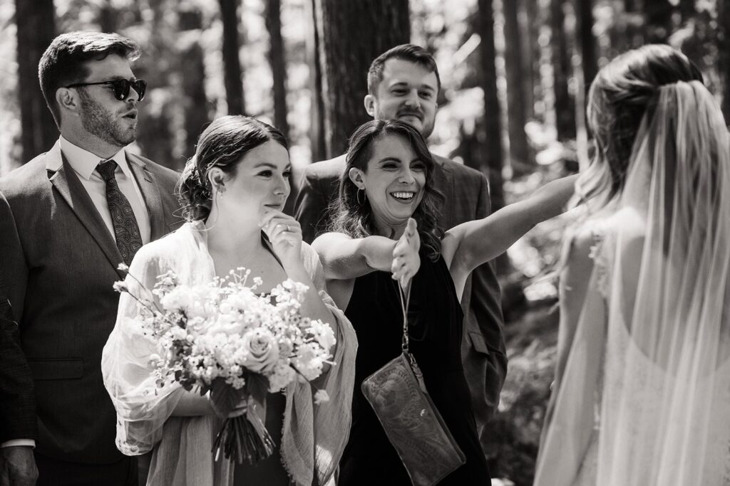 Guests celebrate with hugs after an intimate cabin wedding ceremony in the forest 