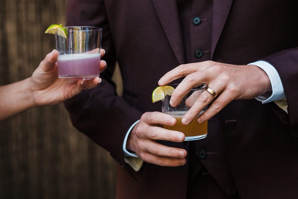 Bride and groom hold custom cocktails during their intimate wedding celebration meal in Washington