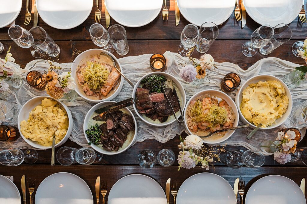 Catered meal lines a table during an intimate cabin wedding celebratory meal