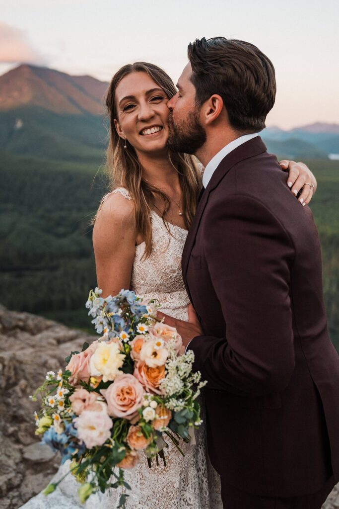 Groom kisses bride on the cheek during their sunset elopement photo session in Snoqualmie Valley