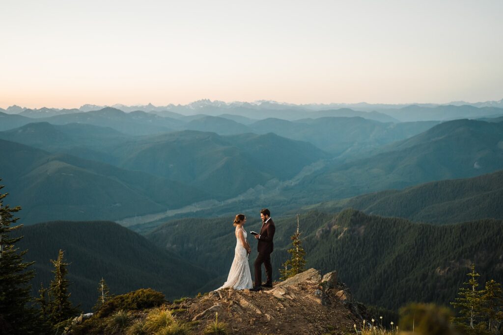 Groom reads vows to bride on a mountain trail near Mount Rainier National Park