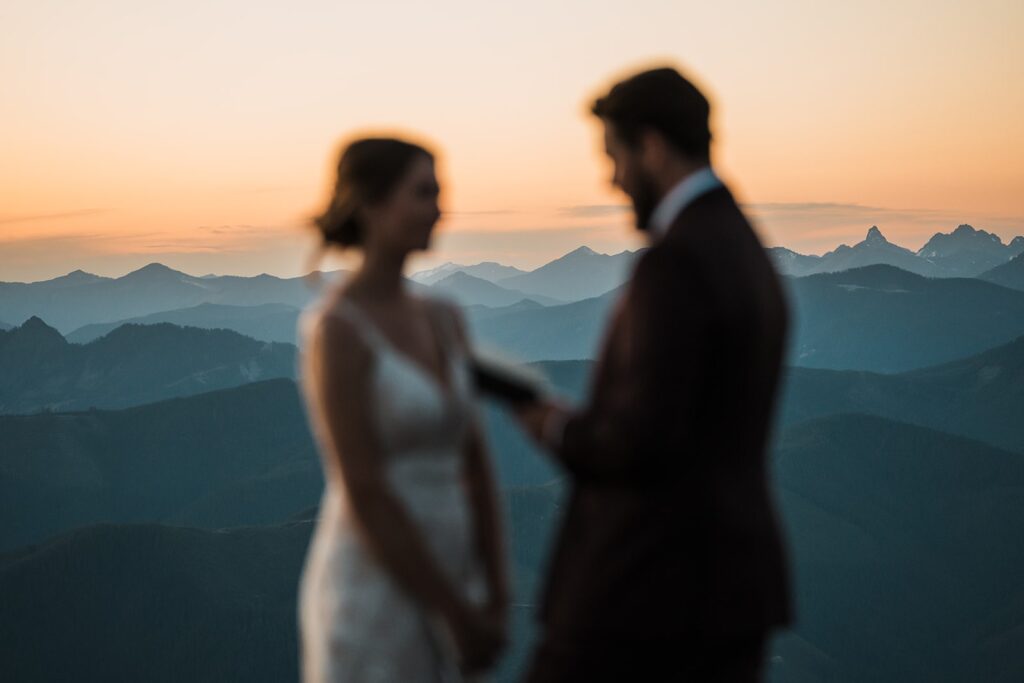 Groom reads vows to bride on a mountain trail near Mount Rainier National Park