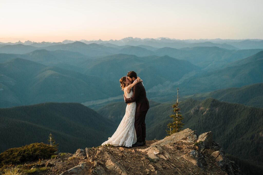 Bride and groom kiss on a mountain trail during their elopement in Washington