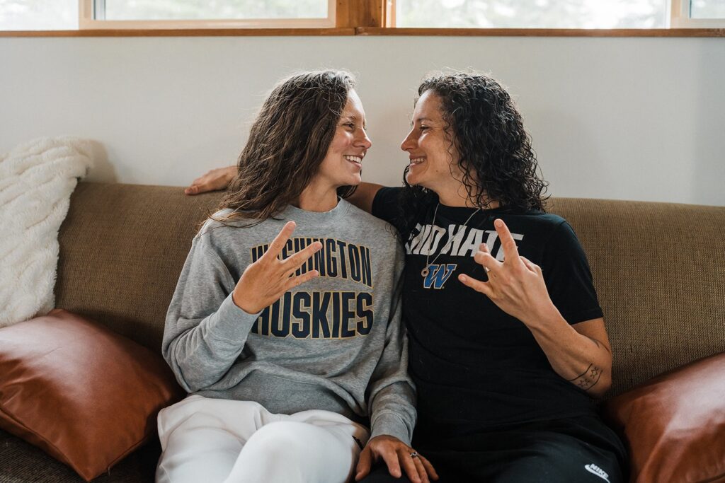 Women sit on the couch before getting ready for their LGBTQ wedding in Washington