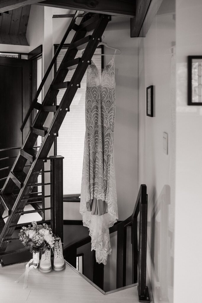 White wedding dress hanging from a wood staircase at an Airbnb cabin in Washington