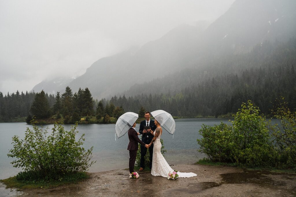 Brides stand under clear umbrellas during their LGBTQ wedding ceremony in Washington