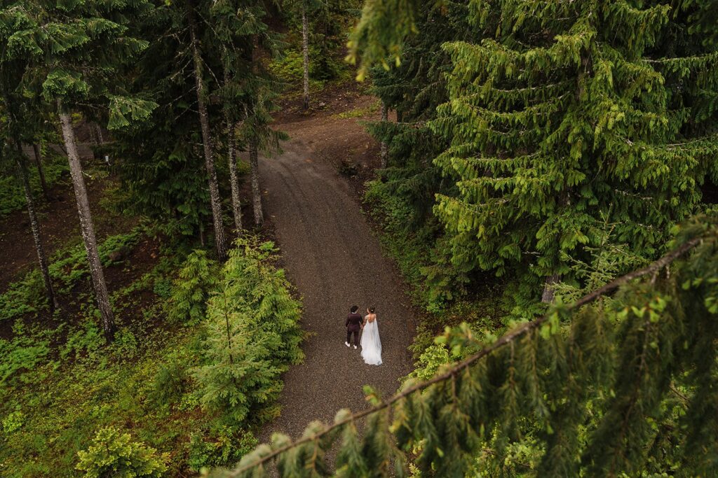 Brides walk through a forest trail during their LGBTQ elopement in Snoqualmie