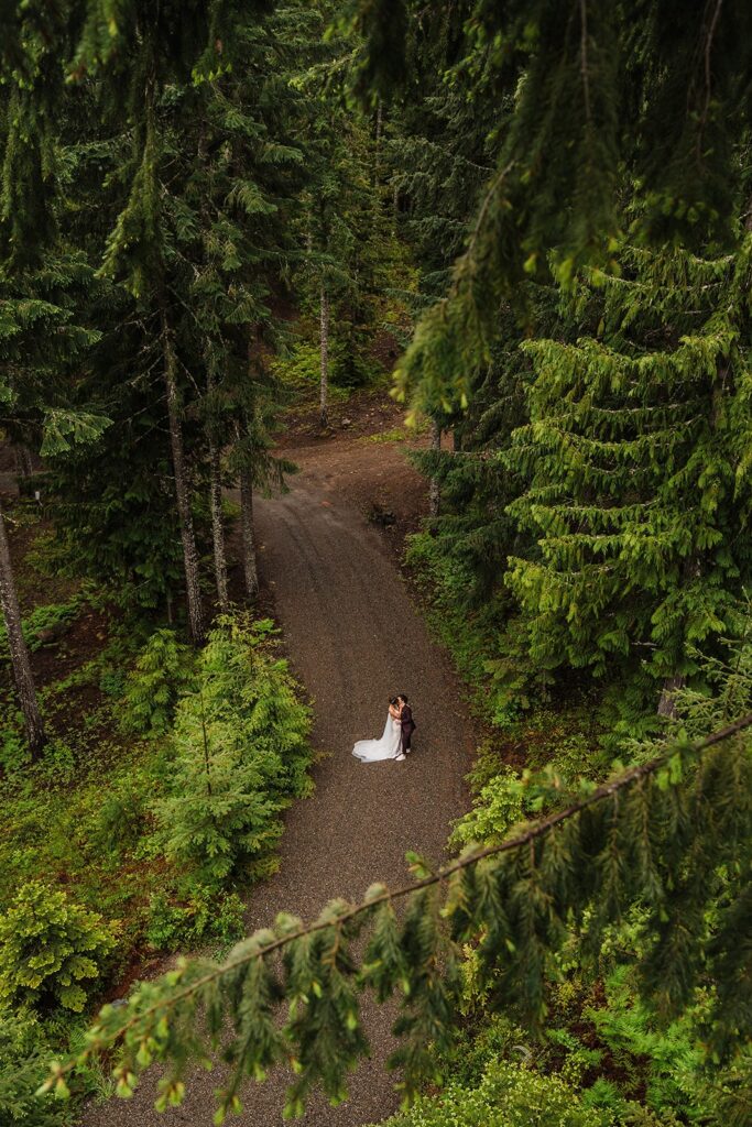 Brides kiss on a forest trail during their LGBTQ elopement in Snoqualmie