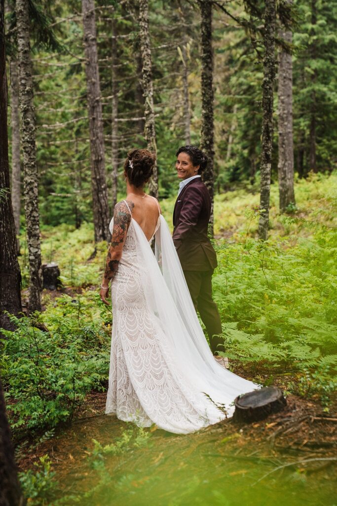 Brides hold hands in the forest during their LGBTQ wedding in Snoqualmie 