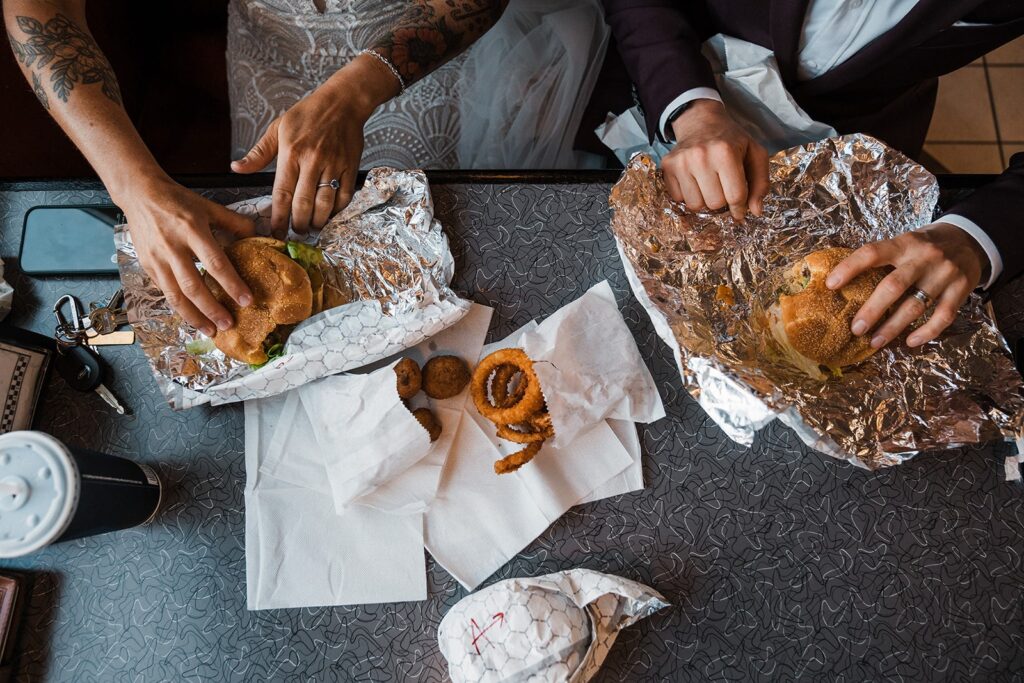 Brides eat burgers before their sunset hike at their LGBTQ elopement in Snoqualmie