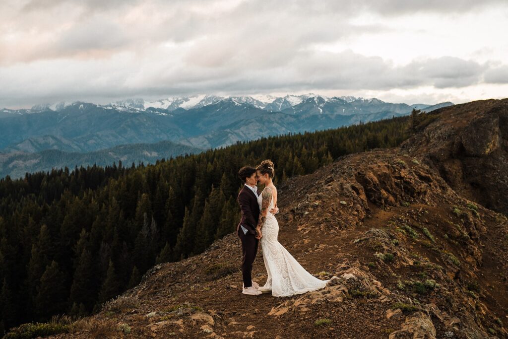 Brides hug on a mountain trail during their Snoqualmie LGBTQ wedding