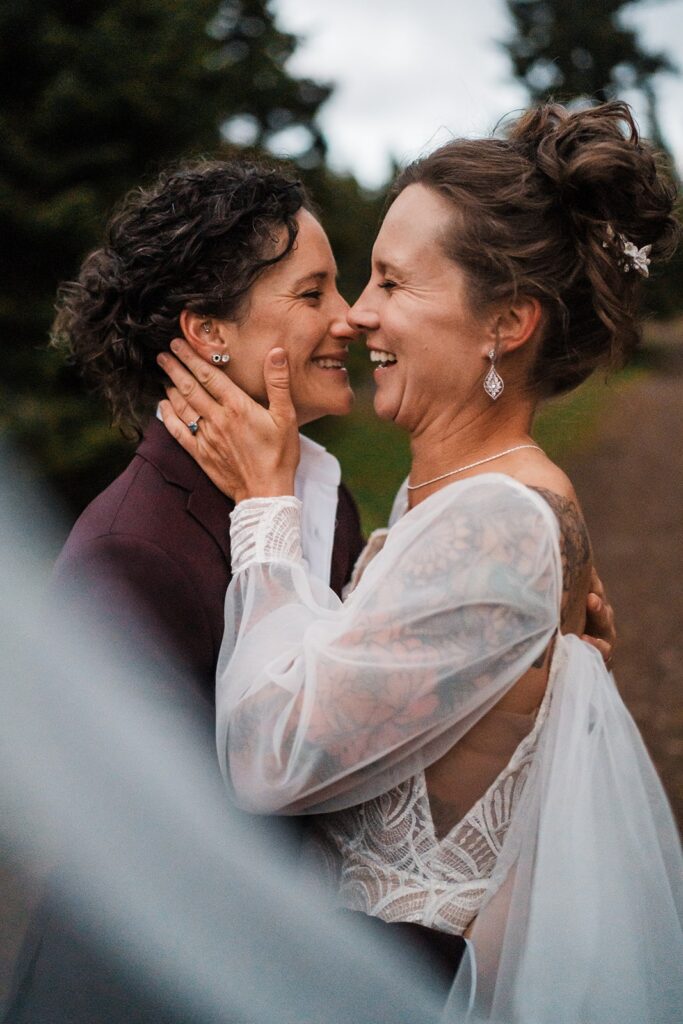 Brides laugh while they hug during their sunset photos at their Washington wedding 