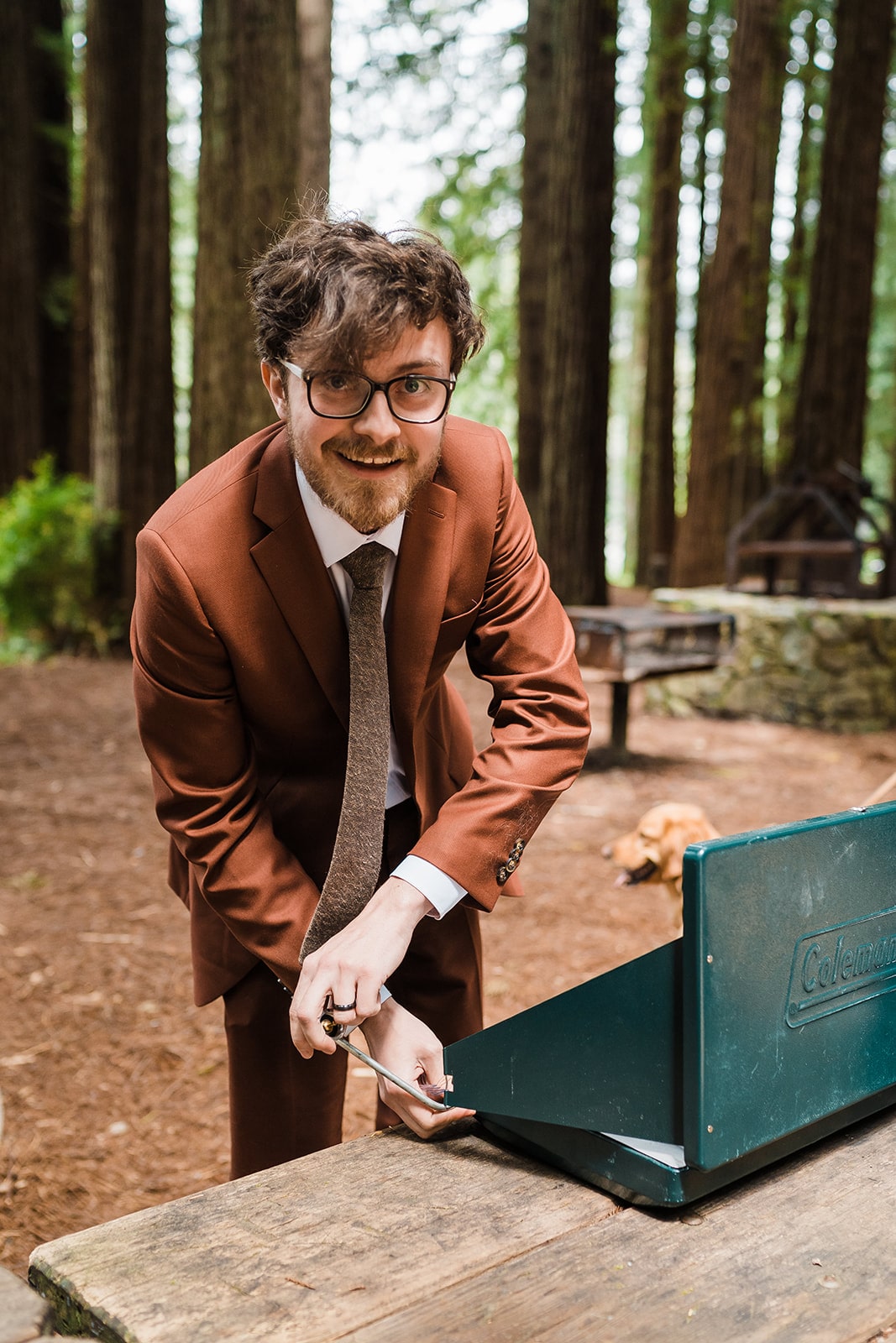 Groom lights a cook stove for his micro wedding venue meal in Oregon