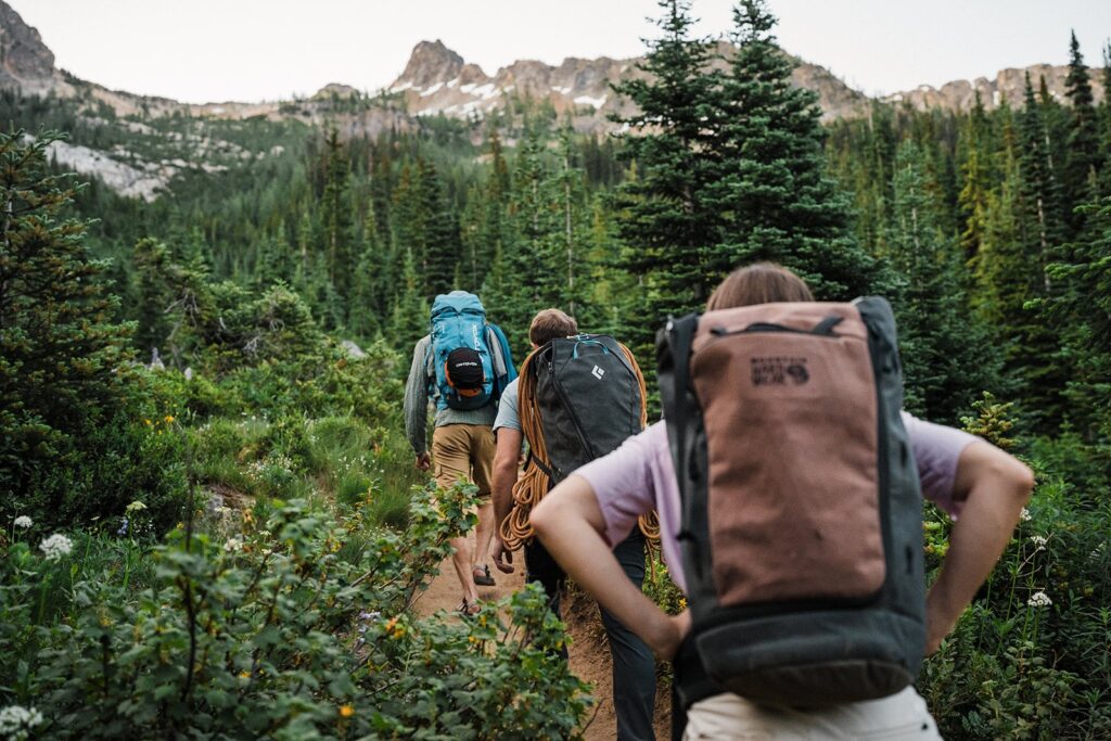 Couple hikes with friends to a mountain summit in the North Cascades