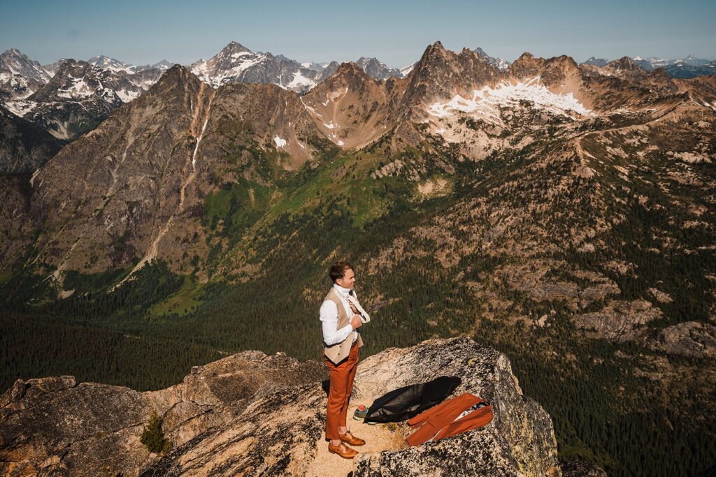 Groom gets ready for his elopement ceremony on top of Liberty Bell in the North Cascades