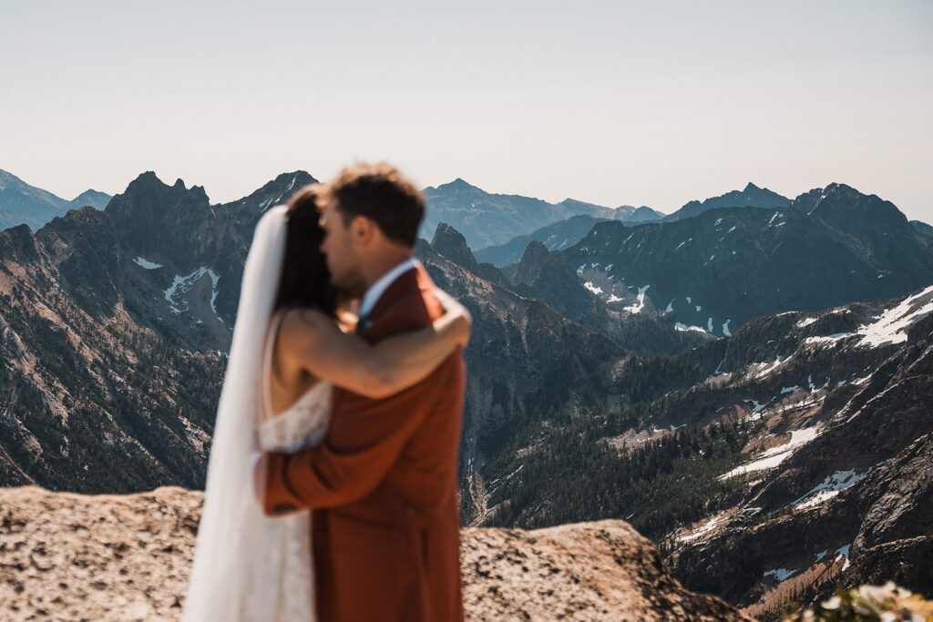 Bride and groom slow dance on top of a mountain peak during their elopement in North Cascades National Park