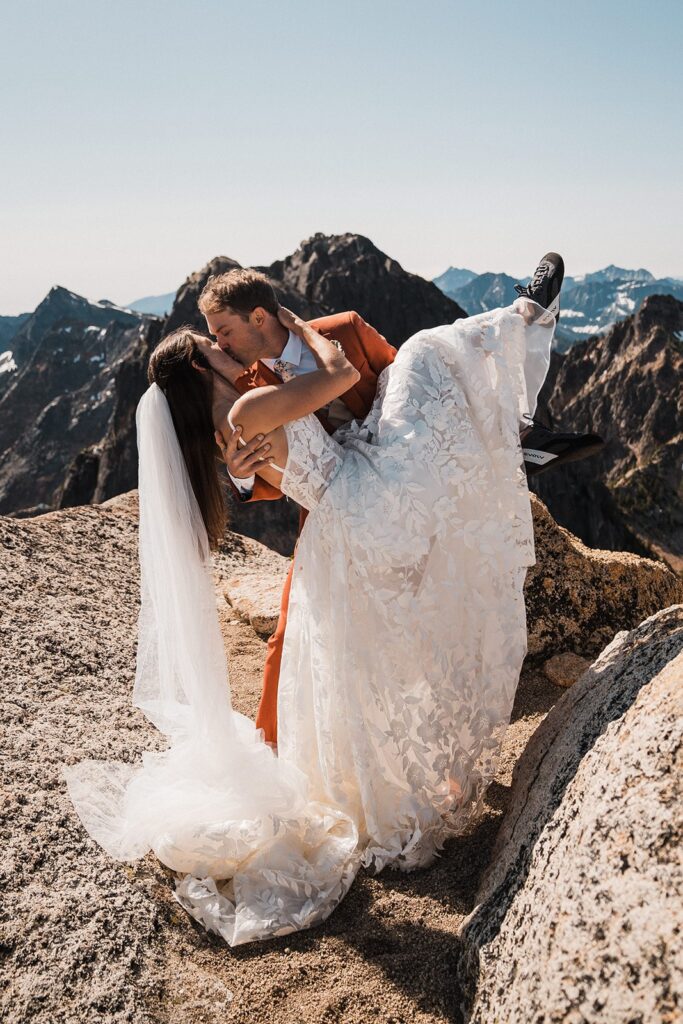 Groom dips bride for a kiss during their North Cascades climbing elopement