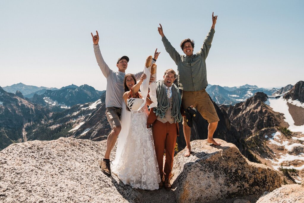 Bride and groom cheer with their friends during their rock climbing elopement in the North Cascades