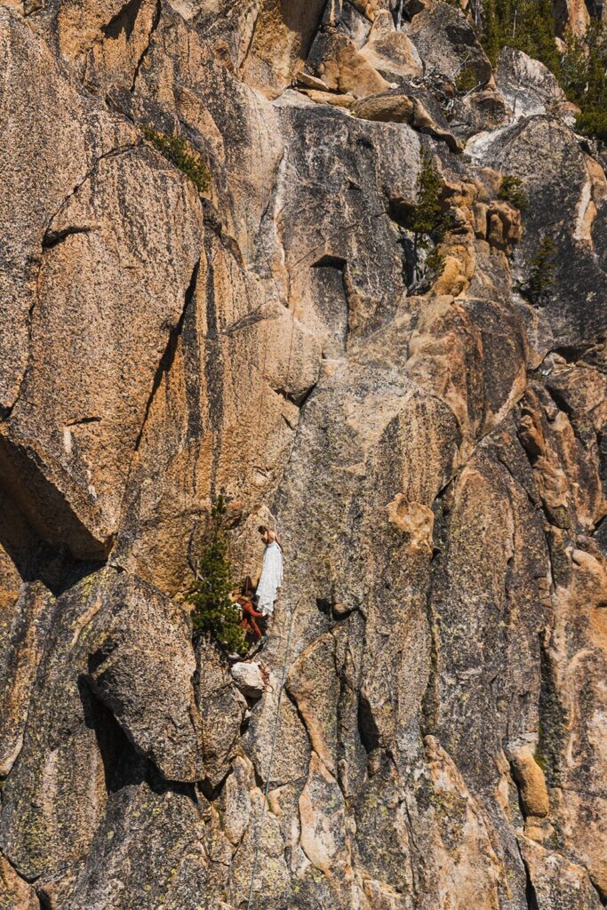 Bride and groom climb a mountain wall during their rock climbing elopement in the North Cascades