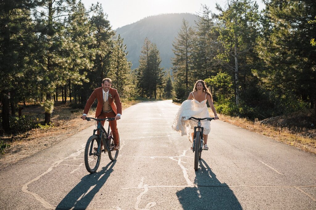 Bride and groom ride mountain bikes through the road during their rock climbing elopement in the North Cascades