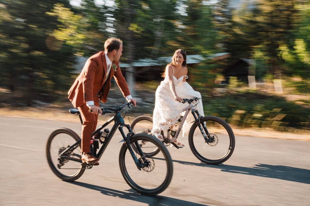 Bride and groom ride mountain bikes through the road during their rock climbing elopement in the North Cascades