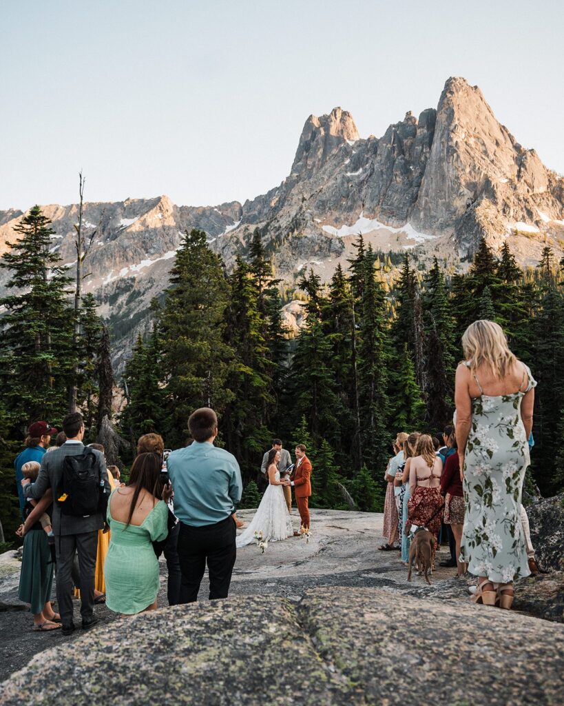 Bride and groom hold hands during their elopement ceremony with guests in North Cascades National Park