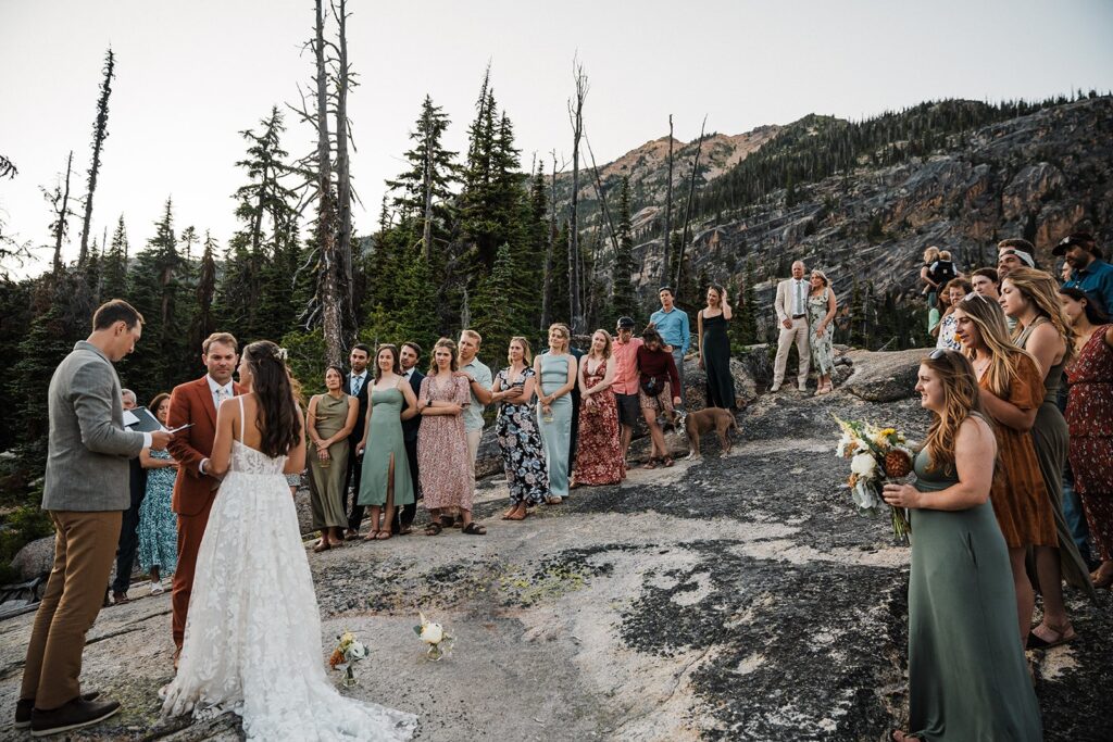 Bride and groom hold hands during their elopement ceremony with guests in North Cascades National Park