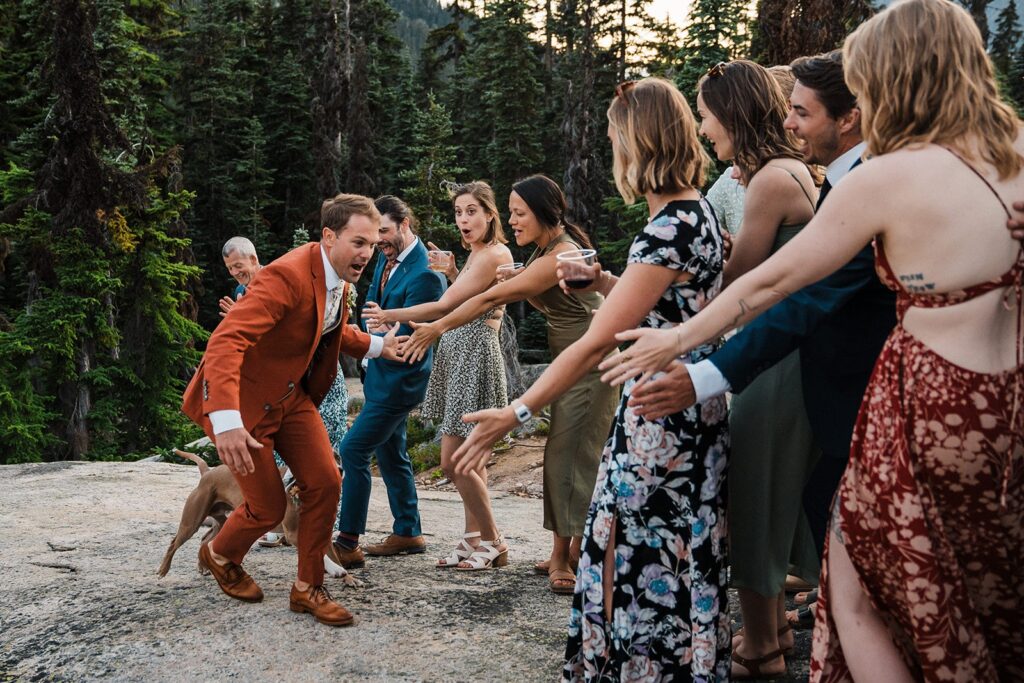 Groom runs and gives high fives to guests after his elopement ceremony in the North Cascades