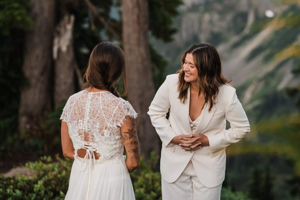 Brides smile during their first look at their summer elopement at Artist Point 