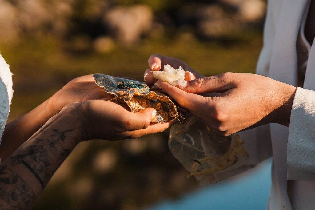 Brides exchange crystals during their Artist Point elopement at sunrise 