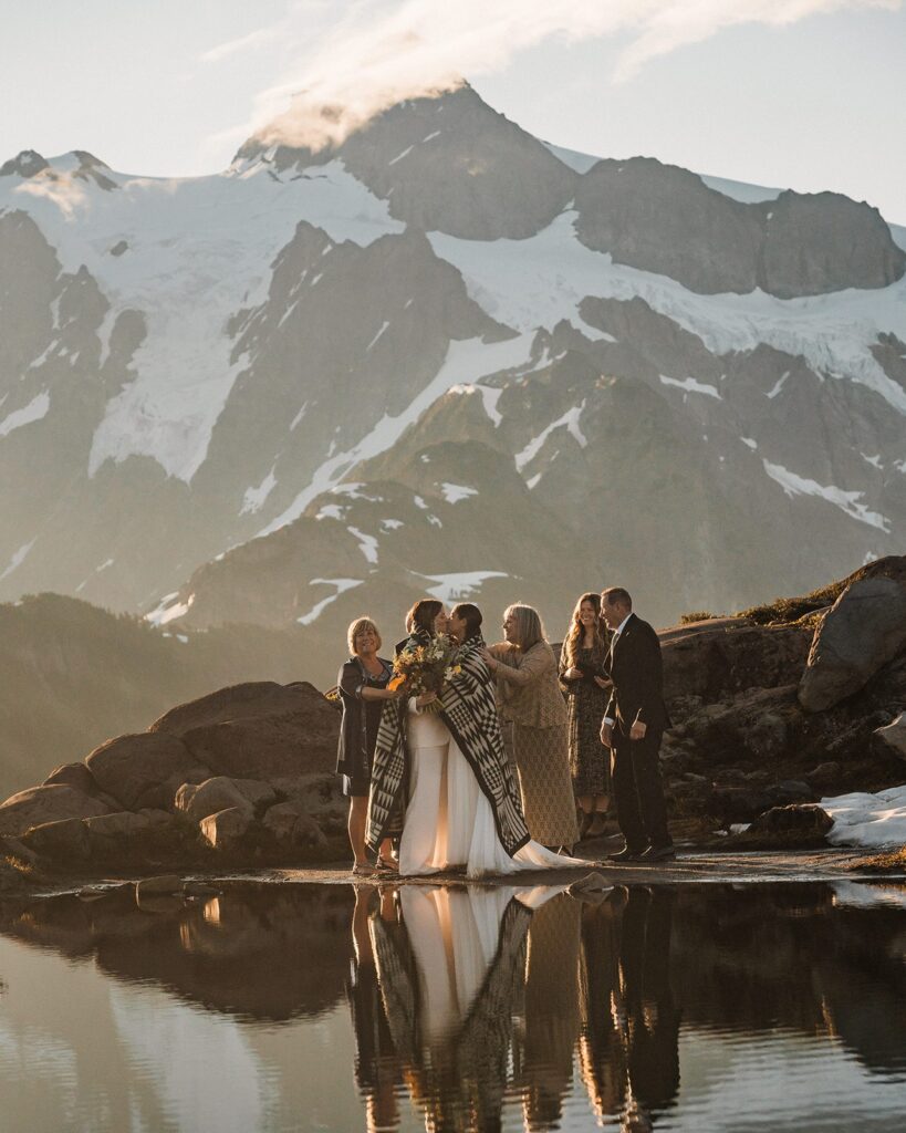 Brides kiss while being wrapped in a Native American blanket during their elopement at Artist Point 