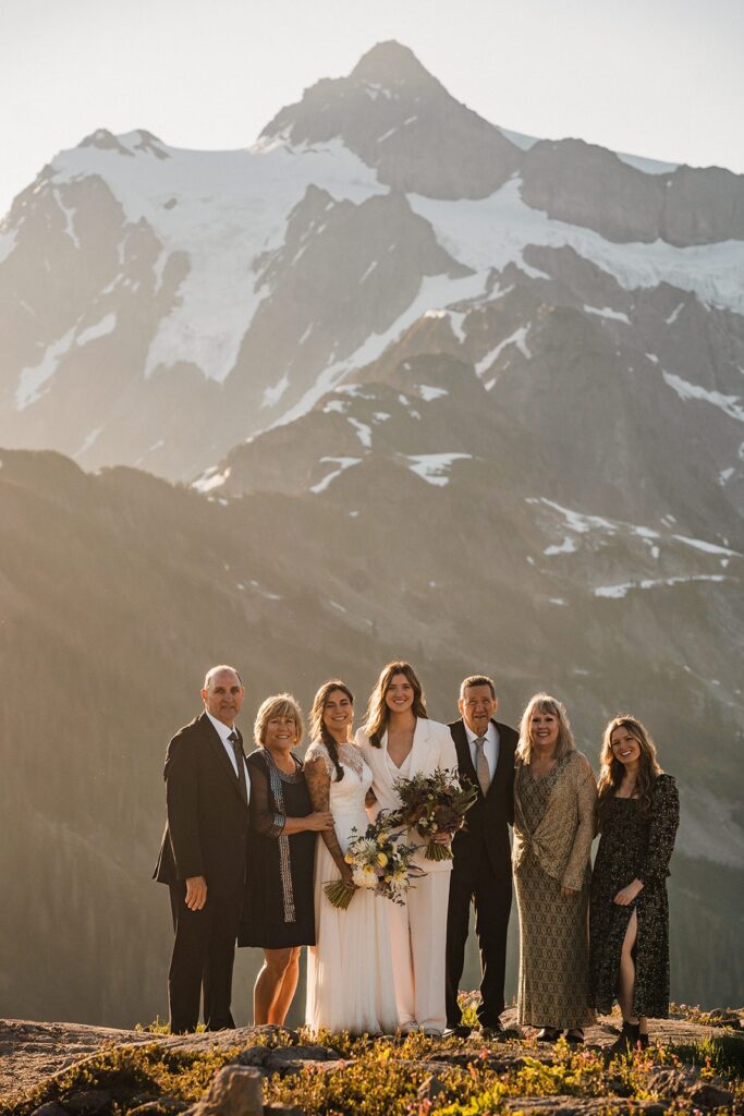 Brides stand on a mountain trail with their parents at their Artist Point elopement 