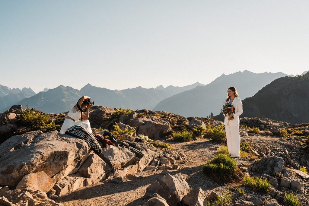 Bride takes a film photo of her bride in the mountains at their summer elopement at Artist Point 