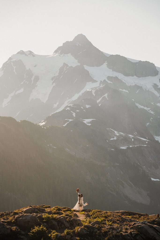 Brides kiss on a mountain trail during their Artist Point summer elopement 