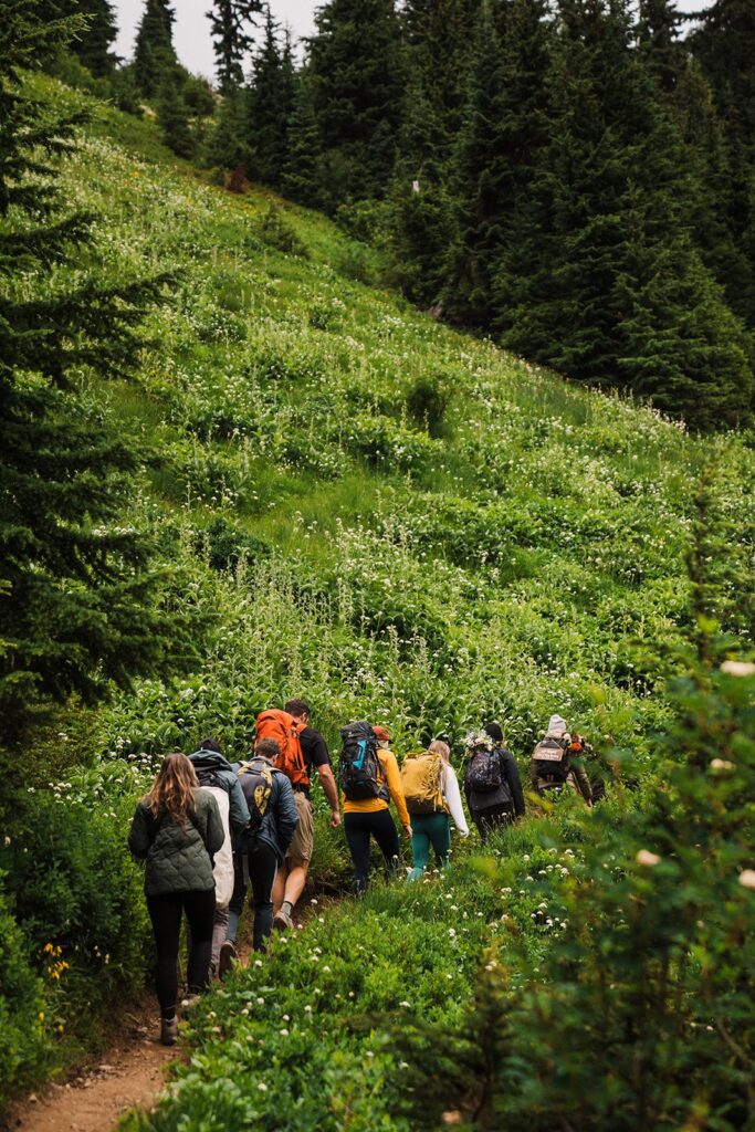 Friends hike a mountain trail in the North Cascades during a summer elopement 