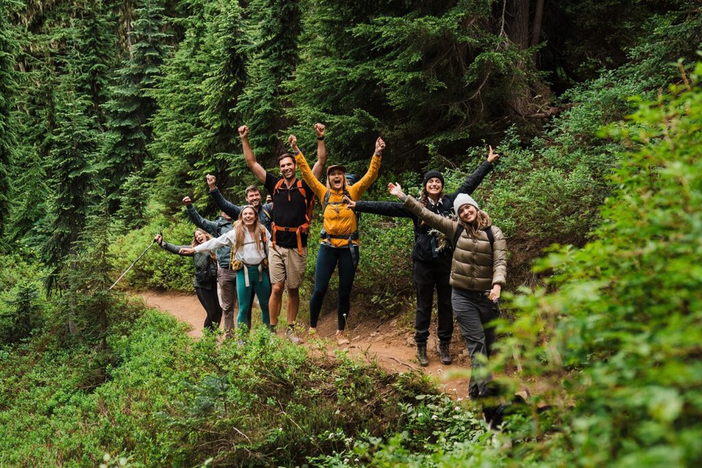 Friends cheer on a hiking trail during a summer elopement in the North Cascades