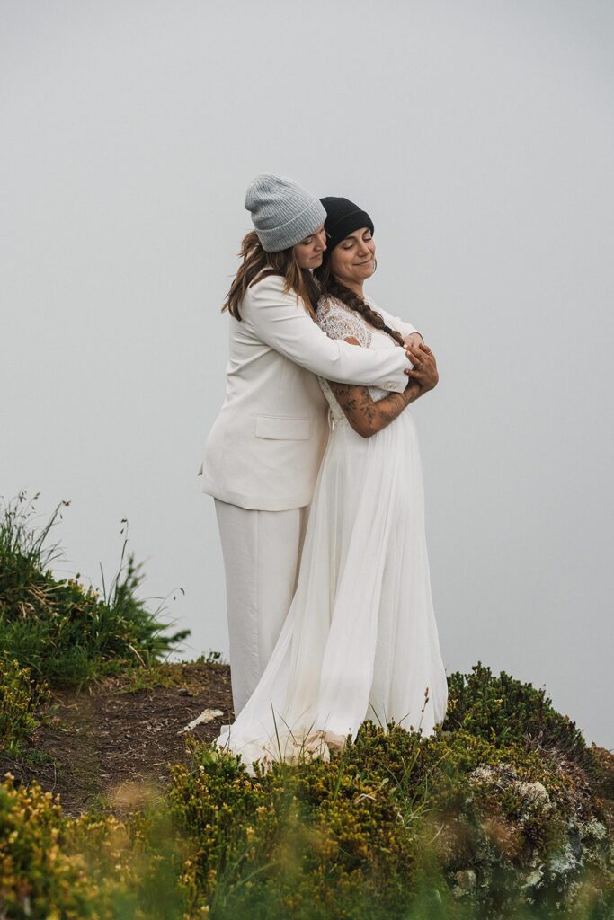 Brides hug during their foggy summer elopement in the North Cascades