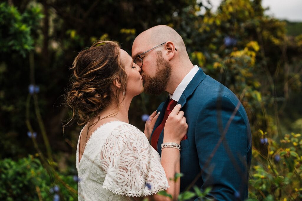 Bride and groom kiss on a rainforest trail during their elopement in Kauai 