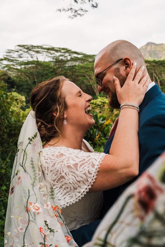 Bride laughs during first look photos at her rainforest elopement in Kauai 