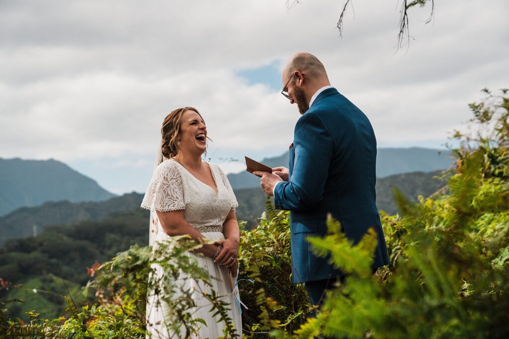 Bride laughs during vow reading at their rainforest elopement in Kauai 