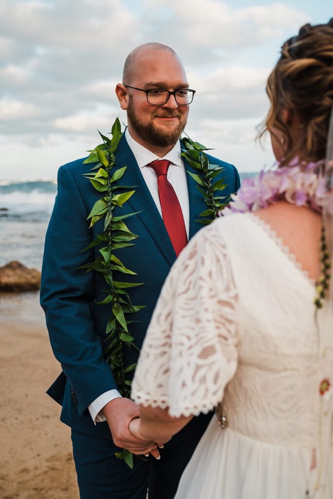 Bride and groom hold hands during their beach elopement in Kauai 