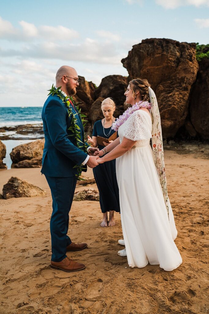 Bride and groom hold hands during their beach elopement in Kauai 