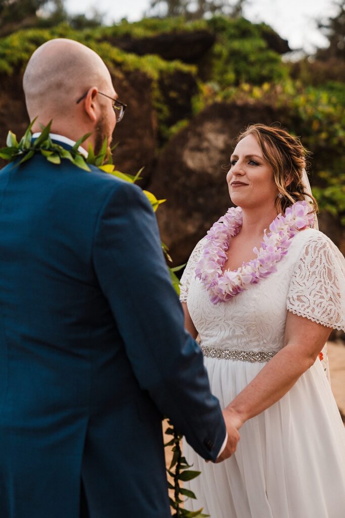 Bride and groom hold hands during their beach elopement in Kauai 