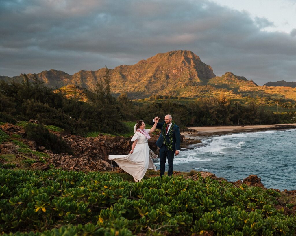 Bride and groom dance on the cliffs during their sunset elopement photos in Kauai 